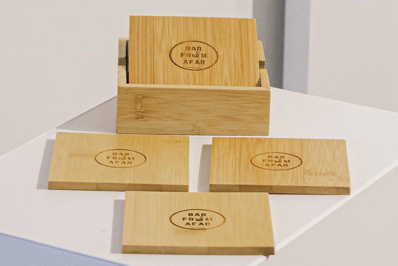 4 wooden square coasters with the bar from afar logo branded into the middle of the coaster. Comes in a wooden box